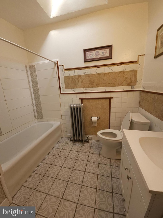 full bathroom with vanity, tile patterned flooring, toilet, tile walls, and radiator heating unit