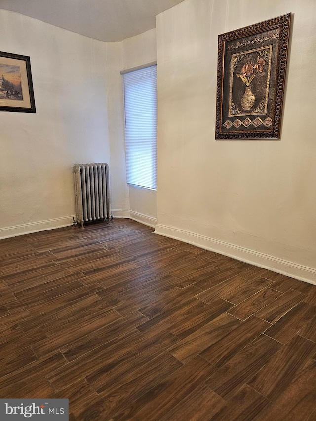 unfurnished room with radiator and dark hardwood / wood-style flooring