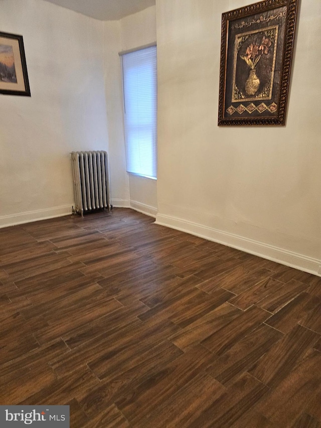 unfurnished room with radiator heating unit and dark wood-type flooring