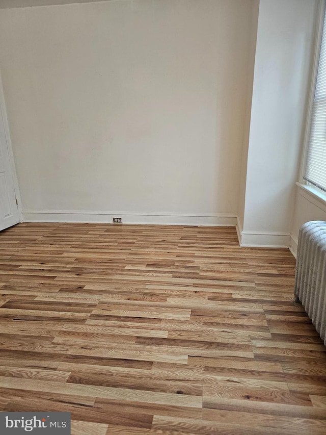 unfurnished room with radiator and light hardwood / wood-style flooring