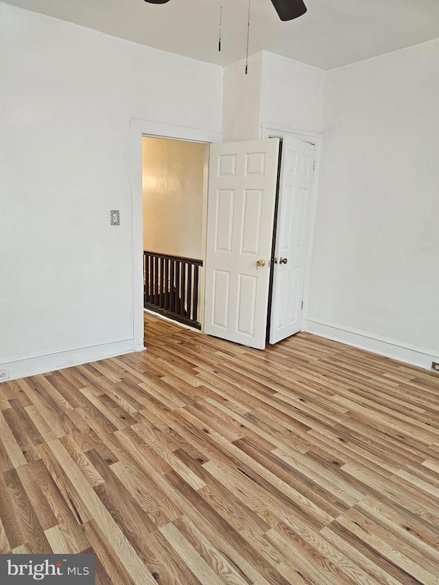 empty room with ceiling fan and light hardwood / wood-style floors