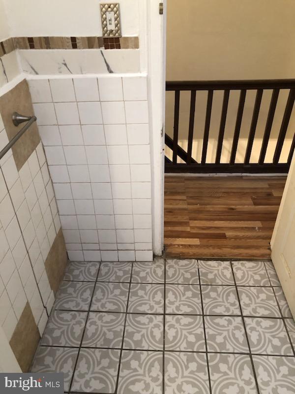 bathroom featuring tile patterned floors and tile walls