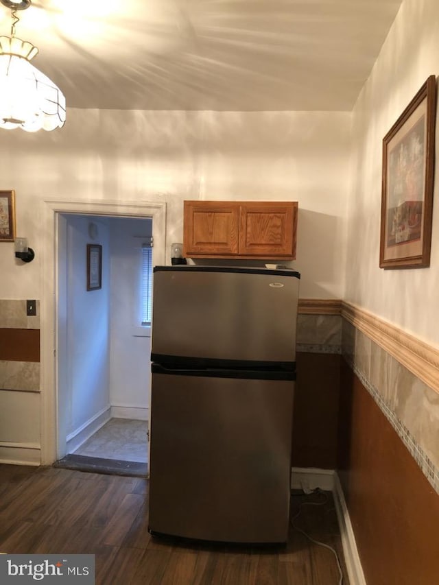 kitchen with dark hardwood / wood-style floors and stainless steel fridge