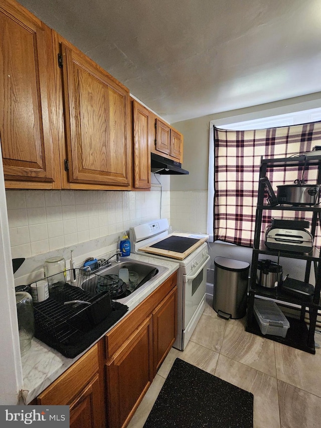 kitchen with backsplash, white range oven, and sink