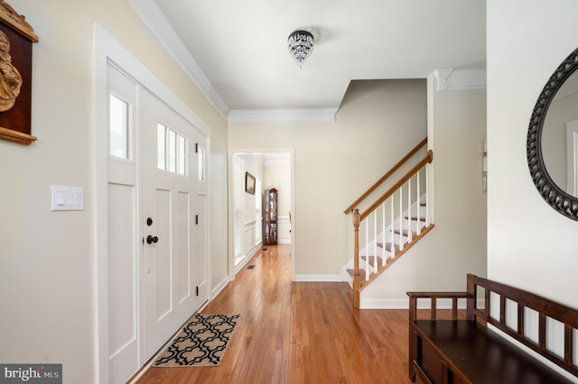 entryway featuring light hardwood / wood-style floors and ornamental molding