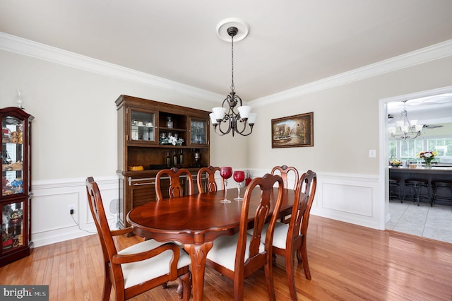 dining room featuring a chandelier, light hardwood / wood-style floors, and ornamental molding