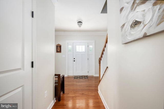 entrance foyer featuring hardwood / wood-style flooring and crown molding