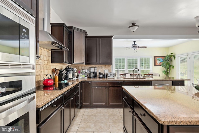 kitchen with black electric stovetop, sink, wall chimney exhaust hood, ceiling fan, and decorative backsplash