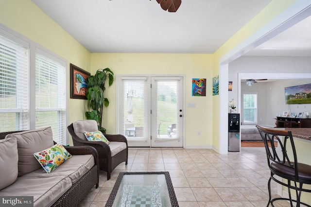 living room with ceiling fan, light tile patterned flooring, and a wealth of natural light