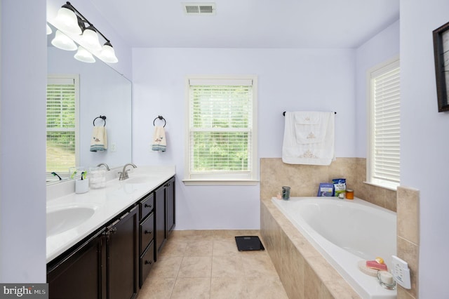 bathroom featuring tile patterned flooring, vanity, and a relaxing tiled tub