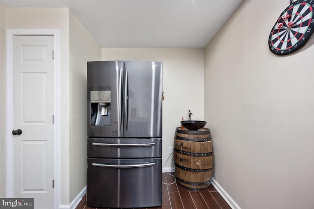 kitchen with stainless steel fridge and dark wood-type flooring