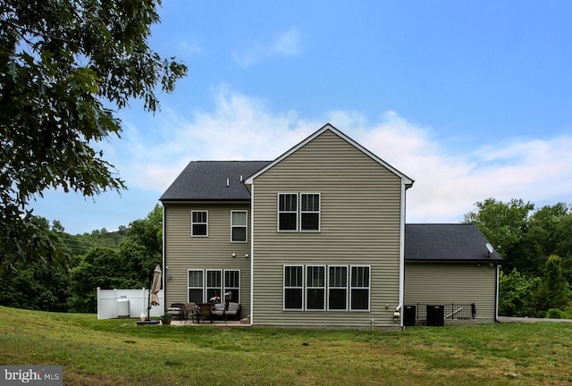 rear view of property featuring a yard, a patio, and cooling unit