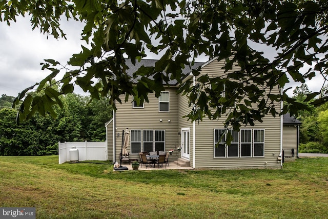 back of house with a yard and a patio