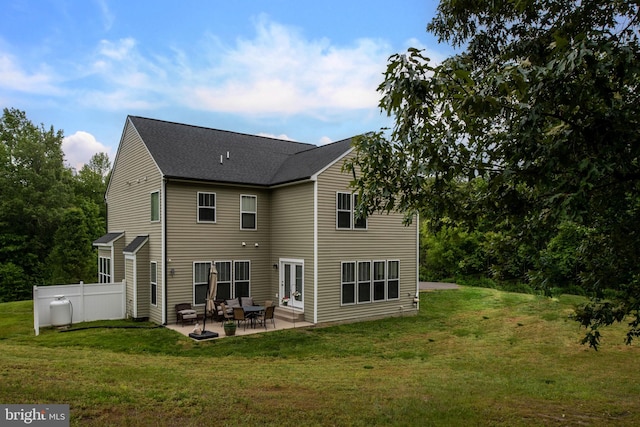 rear view of property featuring a patio area and a yard