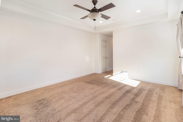 empty room featuring crown molding, ceiling fan, a tray ceiling, and carpet floors