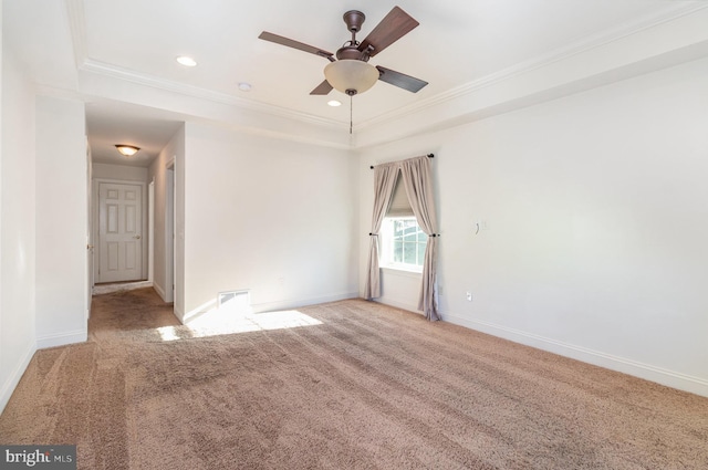 carpeted empty room featuring crown molding, a raised ceiling, and ceiling fan