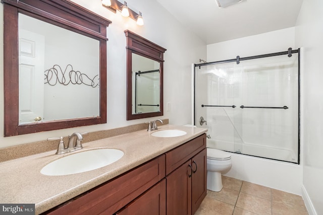 full bathroom featuring vanity, bath / shower combo with glass door, tile patterned floors, and toilet