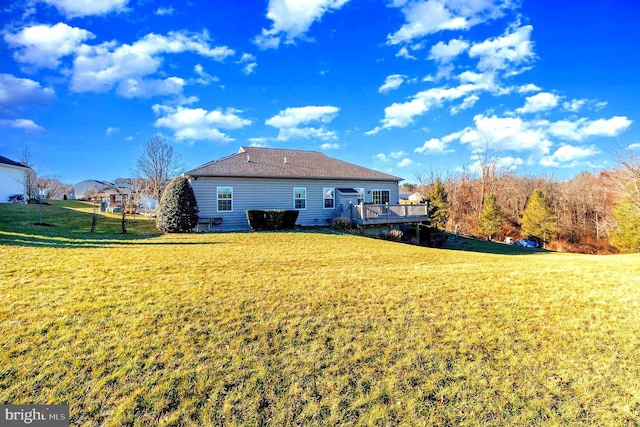 back of property featuring a deck and a lawn