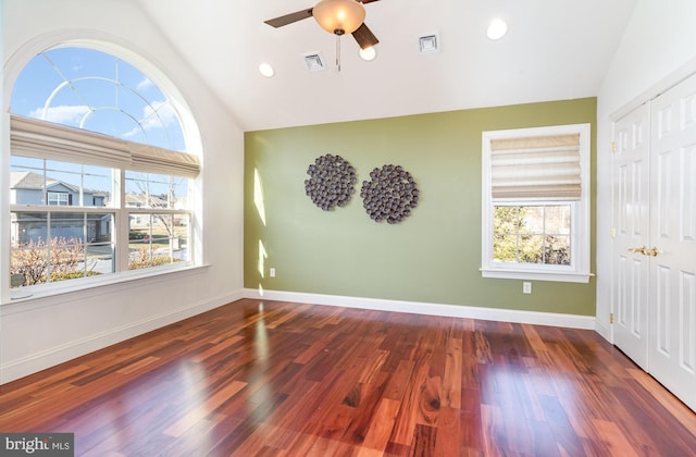 unfurnished bedroom featuring dark hardwood / wood-style flooring, vaulted ceiling, a closet, and ceiling fan