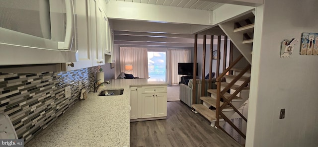 kitchen featuring white cabinets, dark hardwood / wood-style floors, light stone counters, and sink