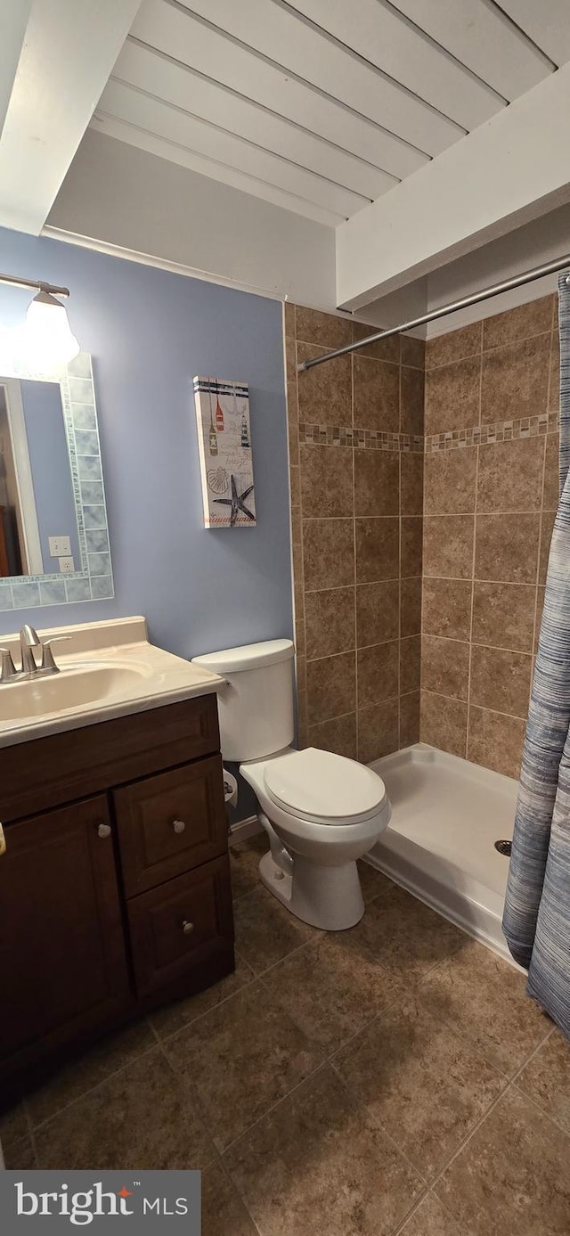 bathroom with a shower with shower curtain, vanity, toilet, and tile patterned flooring