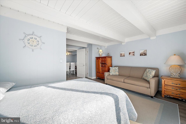 bedroom with beamed ceiling and dark wood-type flooring