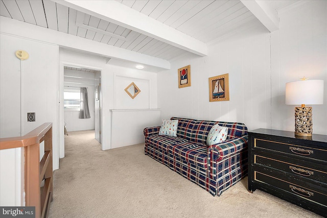 sitting room featuring beamed ceiling and light carpet