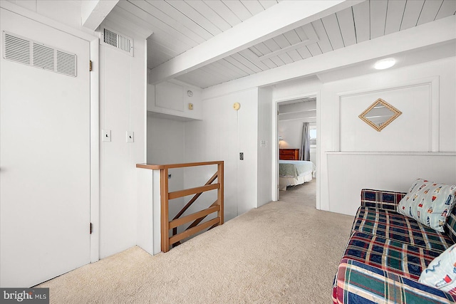 living area featuring beam ceiling and light colored carpet