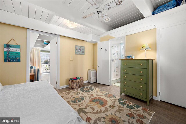 bedroom featuring beamed ceiling, hardwood / wood-style floors, ensuite bath, and ceiling fan