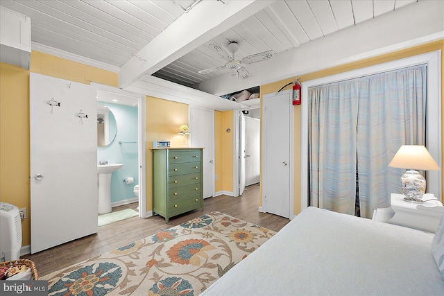 bedroom with hardwood / wood-style floors, wooden ceiling, ceiling fan, connected bathroom, and beam ceiling