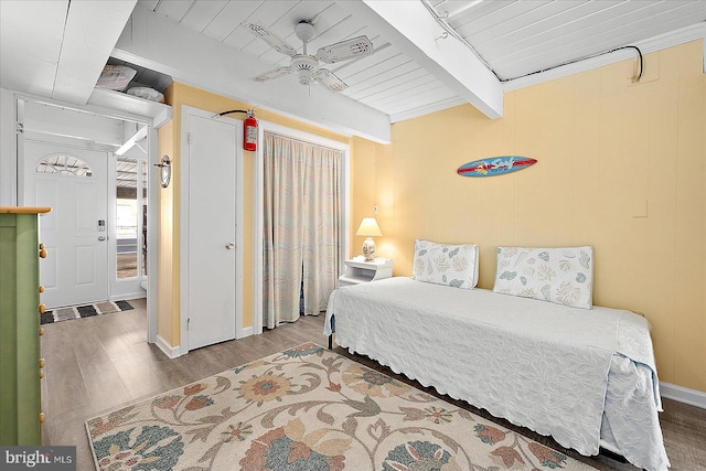 bedroom featuring wood ceiling, ceiling fan, beamed ceiling, and wood-type flooring