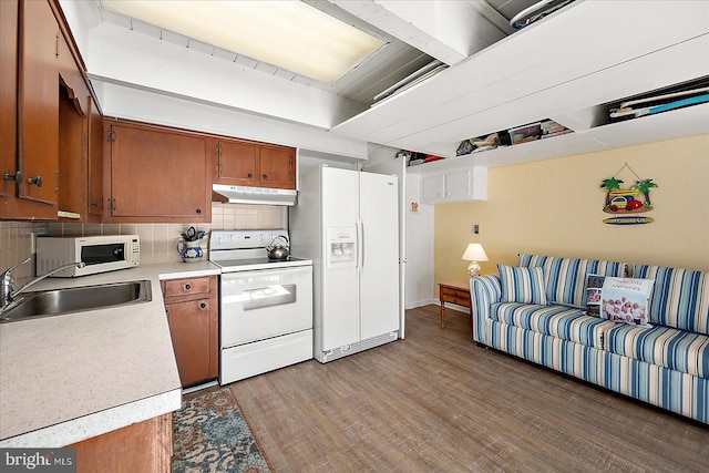 kitchen with white appliances, light hardwood / wood-style floors, tasteful backsplash, and sink