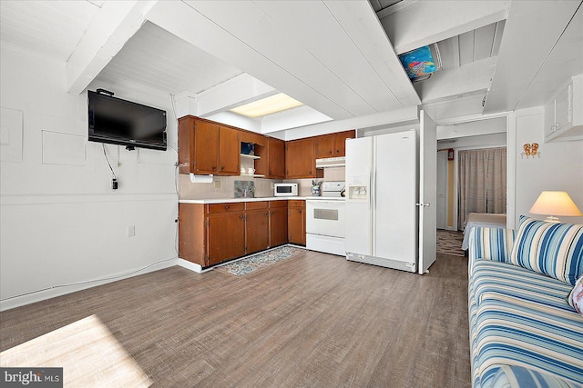 kitchen featuring beam ceiling, sink, light hardwood / wood-style flooring, backsplash, and white appliances