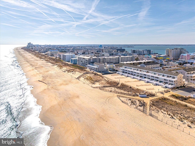 drone / aerial view featuring a beach view and a water view