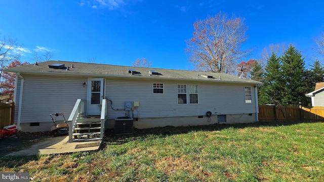 back of property featuring cooling unit and a lawn