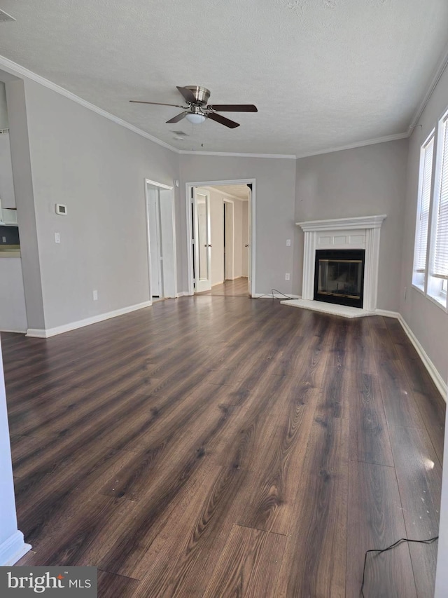 unfurnished living room featuring dark hardwood / wood-style floors, ceiling fan, crown molding, and a textured ceiling