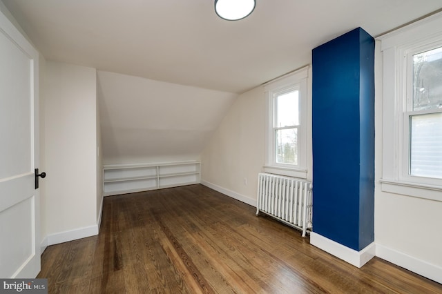 bonus room with radiator, hardwood / wood-style floors, and vaulted ceiling