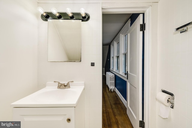 bathroom with radiator heating unit, vanity, and wood-type flooring