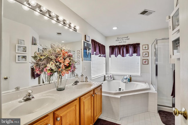 bathroom featuring plus walk in shower, vanity, and tile patterned floors