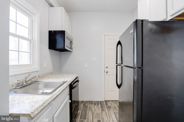 kitchen with white cabinetry, sink, and black appliances