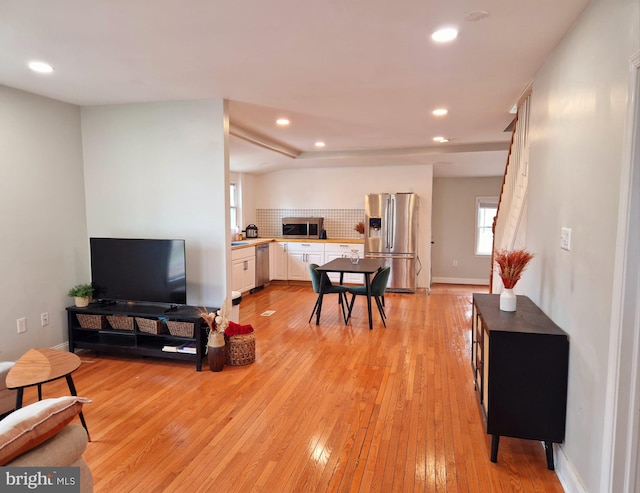 living room with light wood-style flooring, baseboards, and recessed lighting