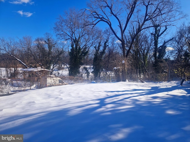 yard layered in snow featuring fence