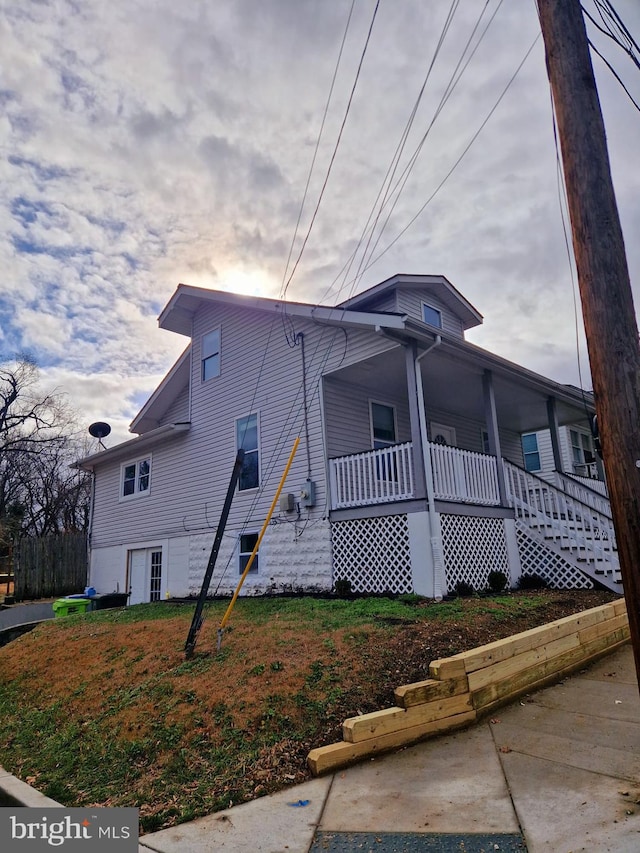 view of property exterior featuring a yard and a porch