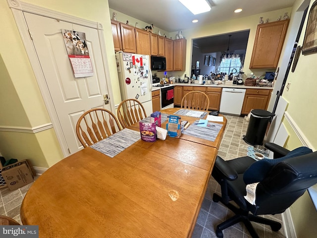 kitchen featuring a chandelier and white appliances