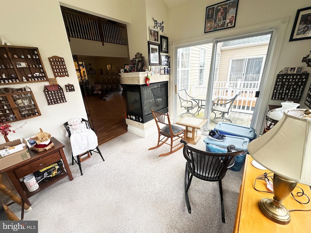 sitting room featuring a multi sided fireplace and carpet flooring