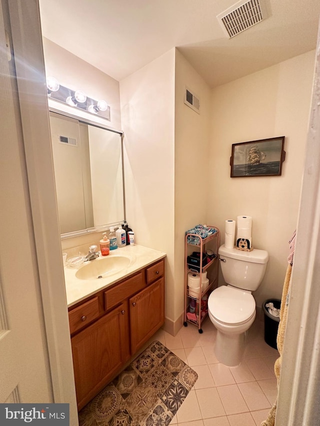 bathroom with tile patterned flooring, vanity, and toilet