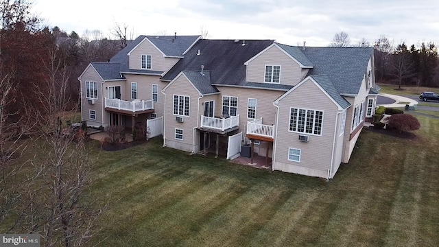 back of house with central AC unit, a balcony, and a yard