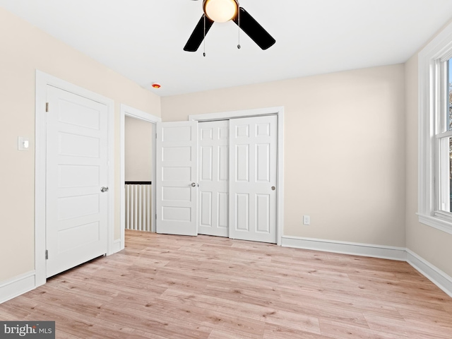 unfurnished bedroom with ceiling fan, light hardwood / wood-style floors, and a closet