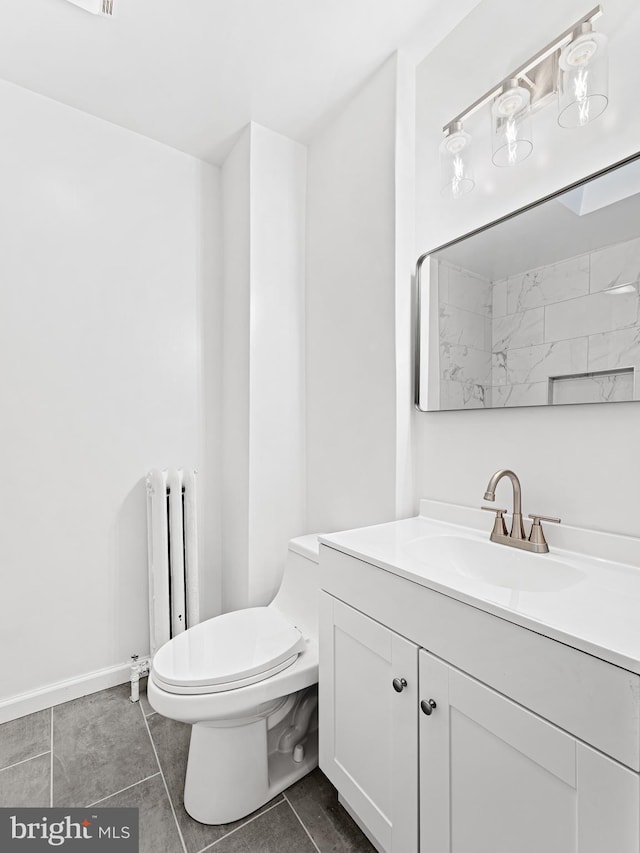 bathroom with tile patterned flooring, vanity, toilet, and radiator