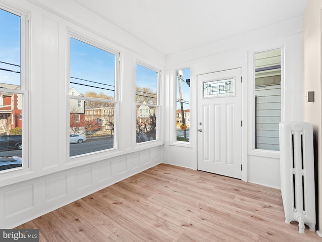 unfurnished sunroom with radiator heating unit